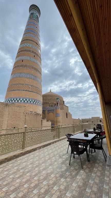 a large building with a table in front of a tower at Khiva Mahliyo in Khiva