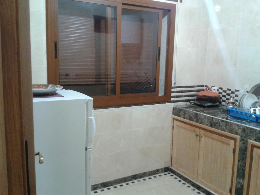 eine Küche mit einem weißen Kühlschrank und einem Fenster in der Unterkunft Dar Al Machichi in Chefchaouen