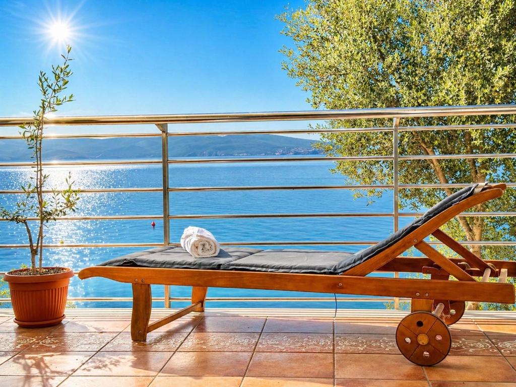 a bench on a balcony with a view of the water at Apartman Nina Selce in Selce