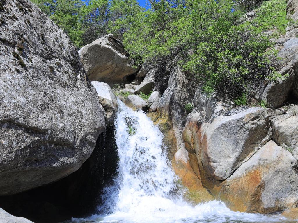 a waterfall in the middle of a mountain with rocks at Ali guest house Samarkand in Aman-Kutan