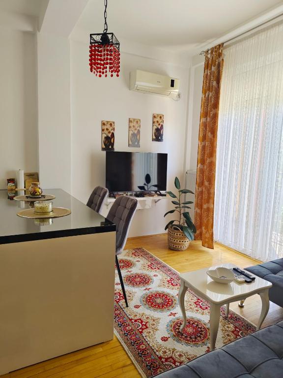 a kitchen and living room with a table and a couch at Apartman Lusi Vranje in Vranje