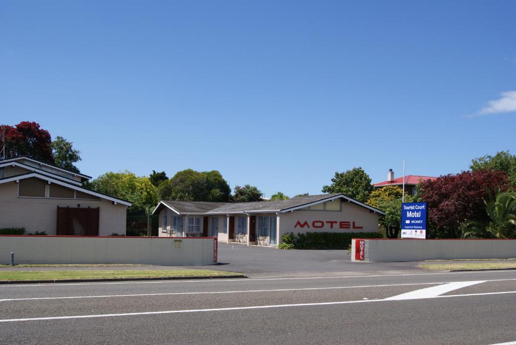 a street with a motel sign on the side of a road at Tourist Court Motel in Whakatane