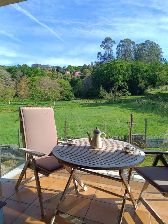 a table and chairs on a patio with a view of a field at Casa Agarimo in Arcade