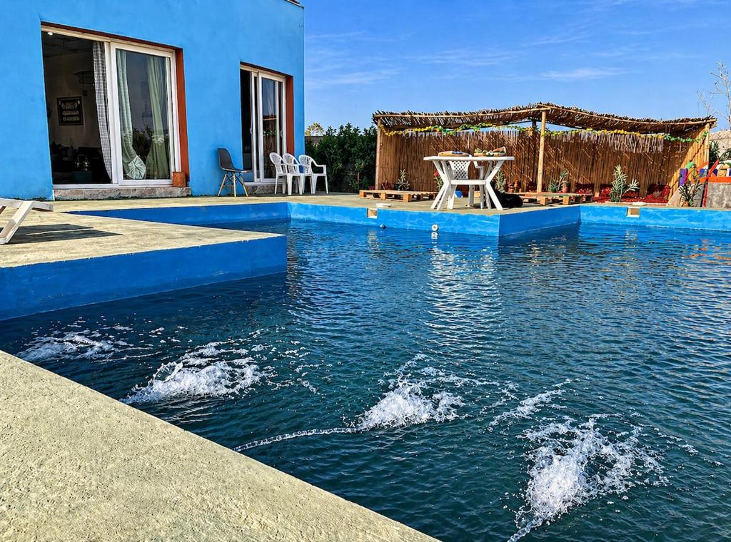 a house with a swimming pool in the water at Blue Escape in Oulad Teïma