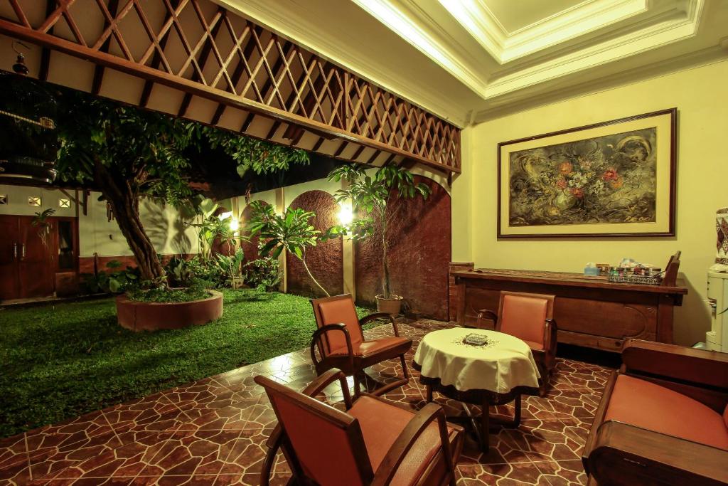 ein Restaurant mit einem Tisch und Stühlen in einem Zimmer in der Unterkunft Griya Langen Guesthouse in Yogyakarta