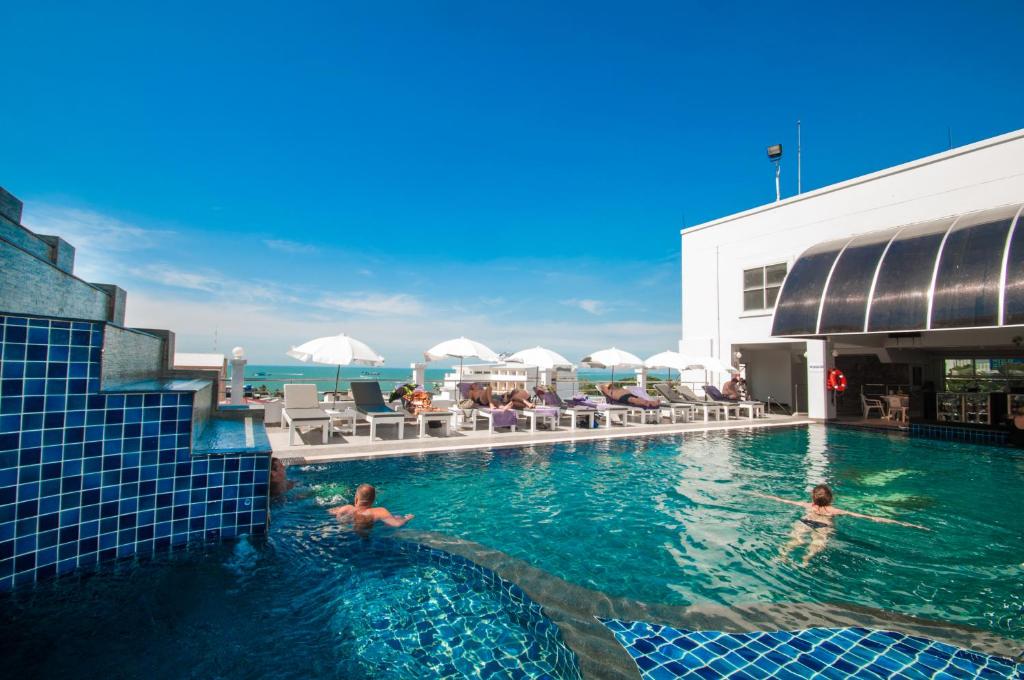Una piscina en un hotel con gente en el agua. en Flipper House Hotel - SHA Extra Plus, en Pattaya central