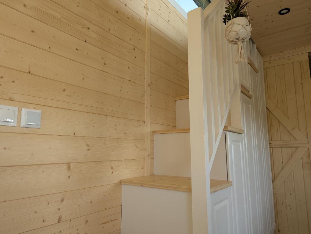 a wooden paneled room with a staircase in a tiny house at Les Nids de Cerisy in Cerisy-la-Forêt