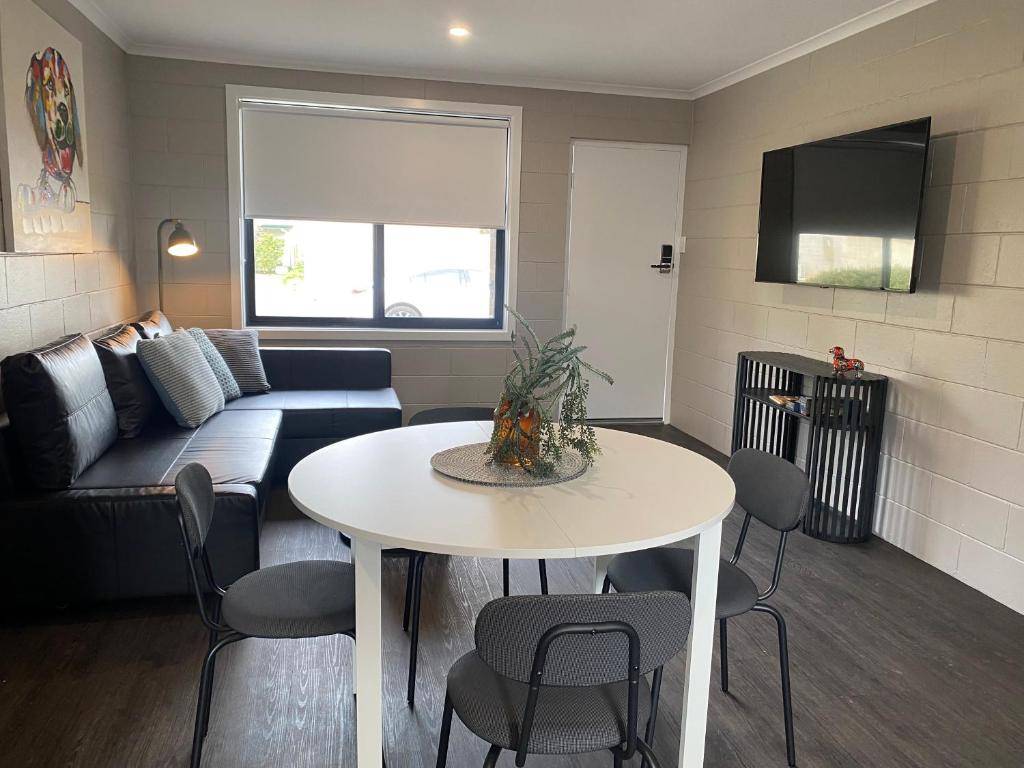 ein Wohnzimmer mit einem Tisch und einem Sofa in der Unterkunft McInnes Units in Naracoorte