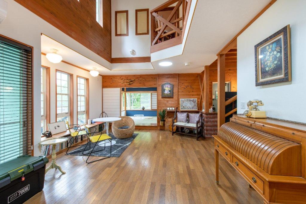 a large room with wooden walls and a ceiling with a piano at S-villa那須Audrey in Nasu