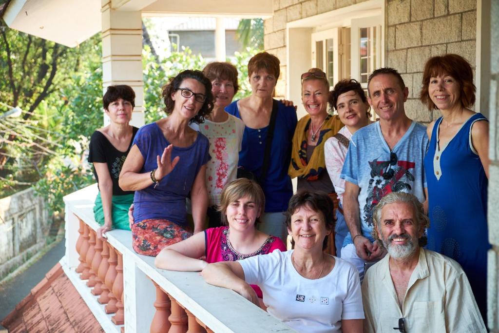 a group of people standing on the porch of a house at Hebron Inn in Cochin