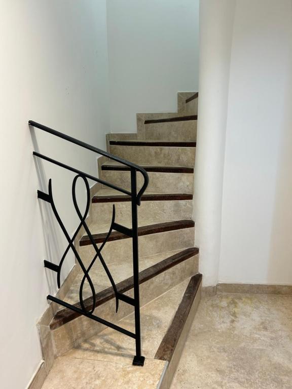 eine schwarze Metalltreppe in einer weißen Wand in der Unterkunft Suite Maison Roche in Carpentras