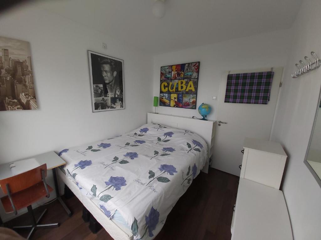 a bedroom with a bed with blue flowers on it at sky home room 2 in Amsterdam
