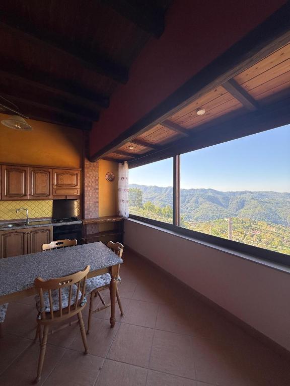 a kitchen with a table and chairs and a large window at Casa Vacanze Panoramika Santa Cruz - Appartamento PANORAMIKA in Cicerale