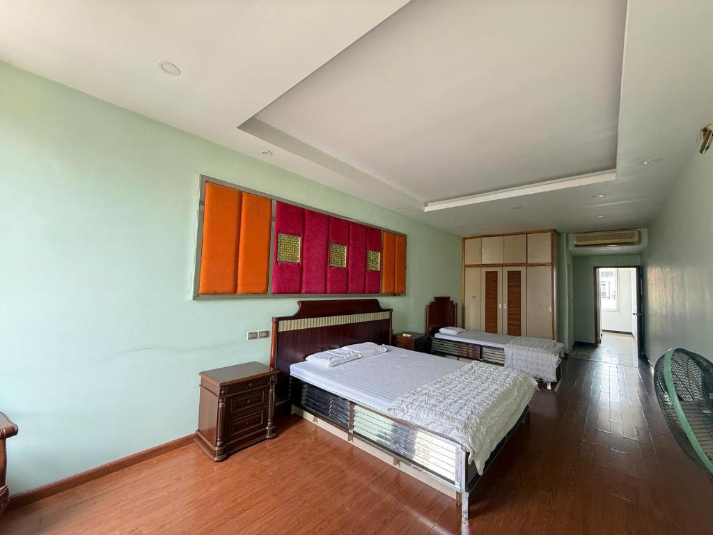 a bedroom with two beds and a painting on the wall at Chiều Hotel in Ha Long
