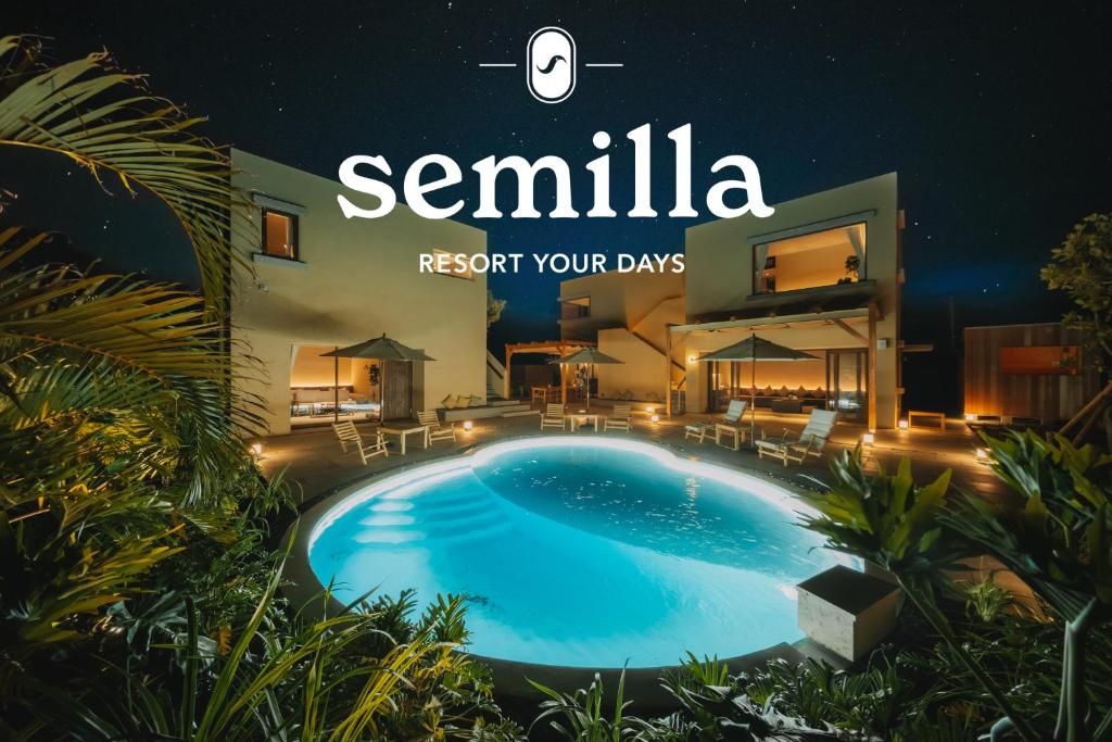 a sign for a villa with a swimming pool at night at semilla 名護 沖縄 in Nago