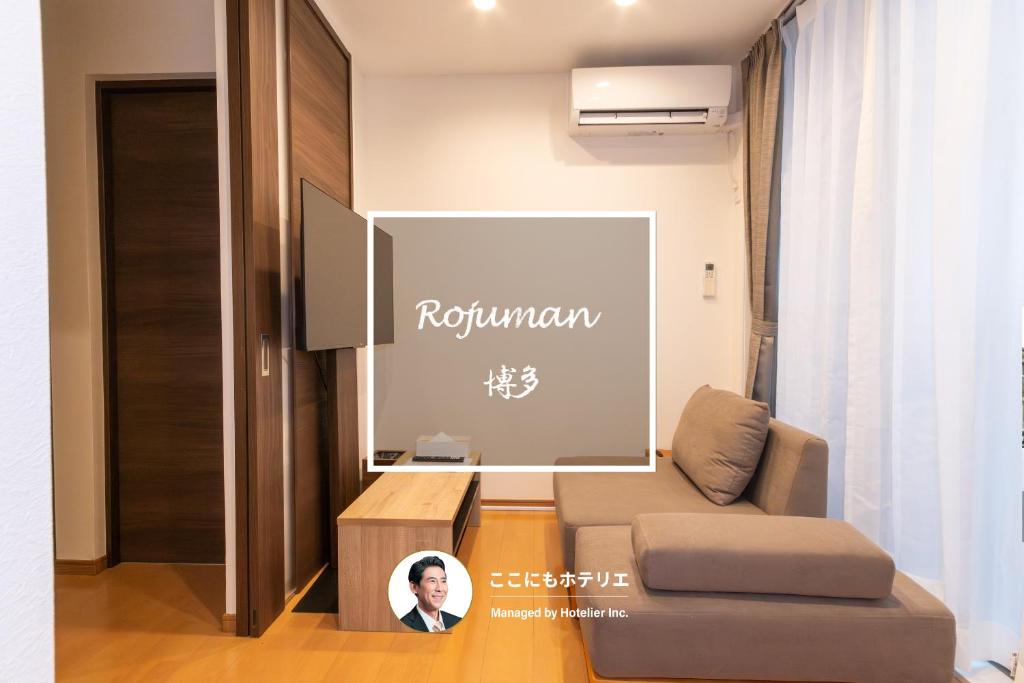 a living room with a couch and a tv at Rojuman Hakata in Hakata