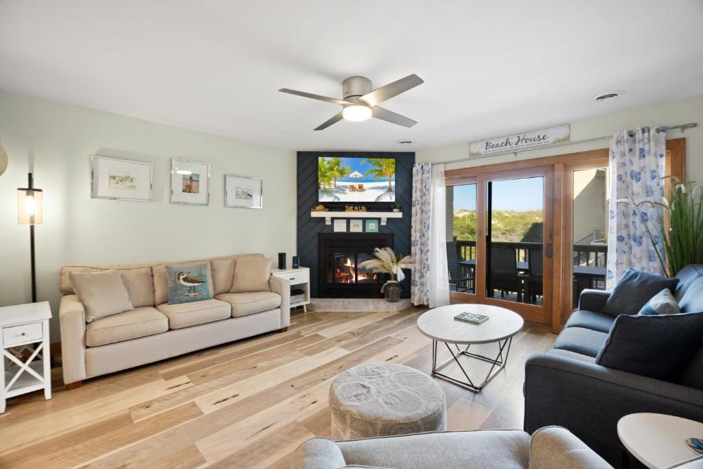 a living room with a couch and a tv at QCB5 - Saltaire Sunrise in Nags Head