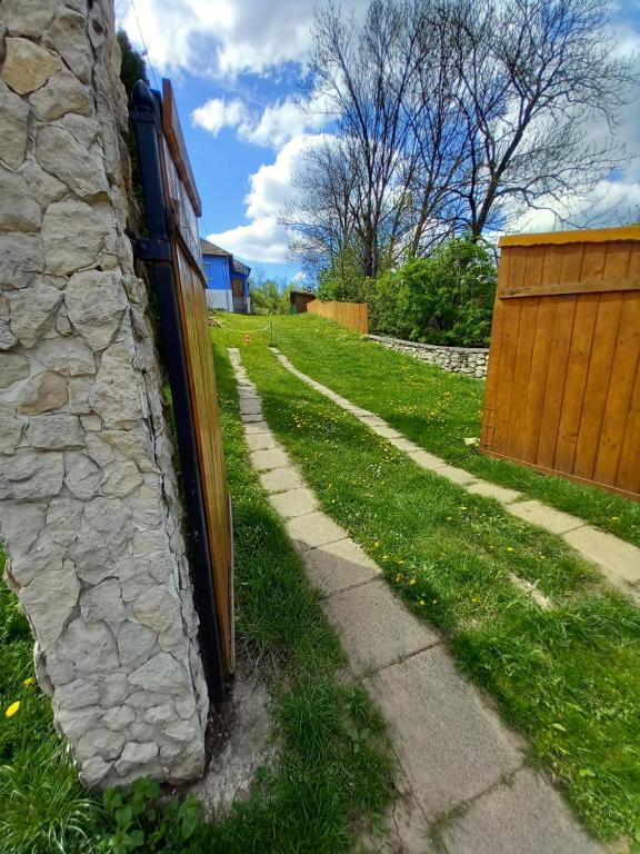 a stone wall next to a sidewalk next to a yard at Casa La Casiru 17 nature in Straja