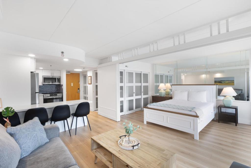a bedroom with a bed and a living room at Ilikai Tower 1936 condo in Honolulu