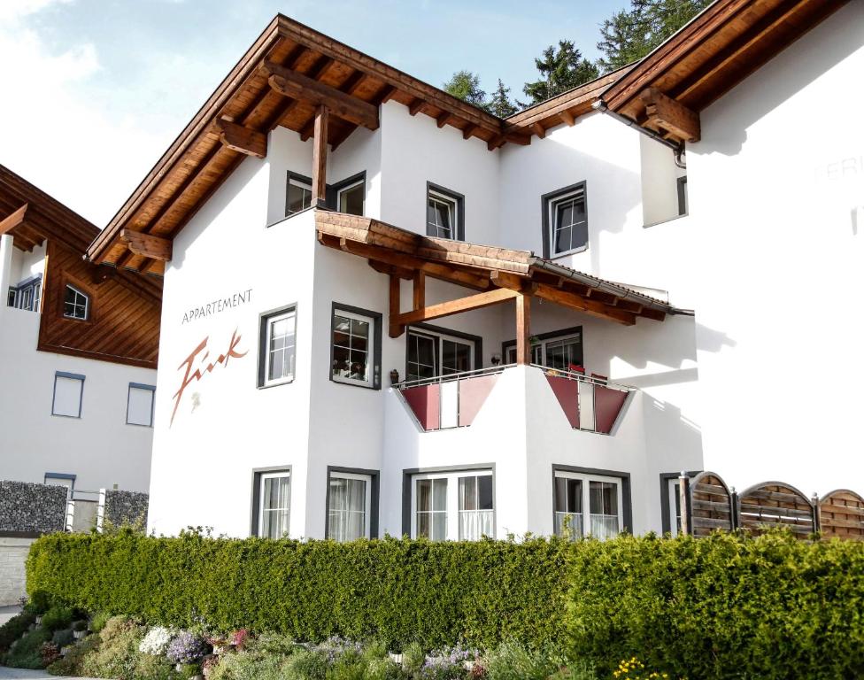 a white building with a wooden roof at Appartement Fink in Jerzens