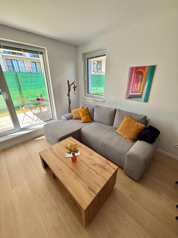 a living room with a couch and a wooden coffee table at Stylish Chill Garden Apartment in Bratislava