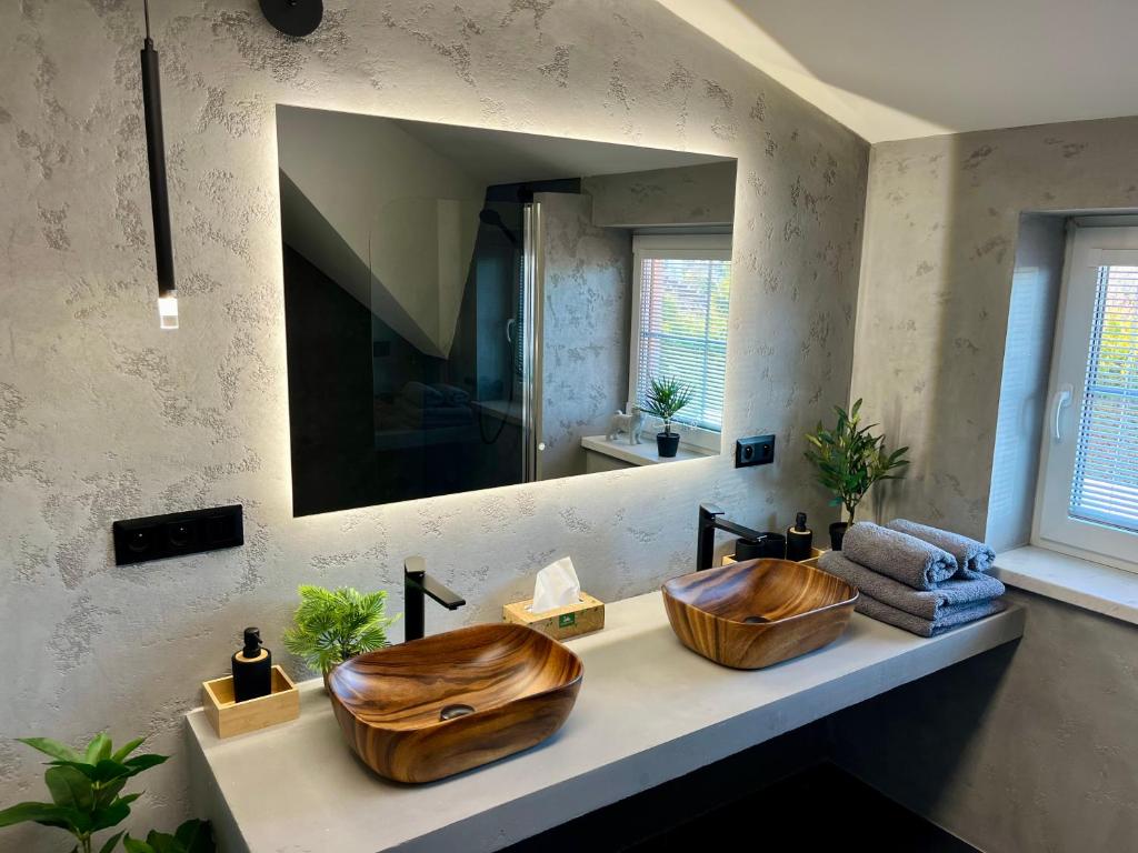 two wooden sinks in a bathroom with a mirror at Vila SoHo in Vysoké Mýto