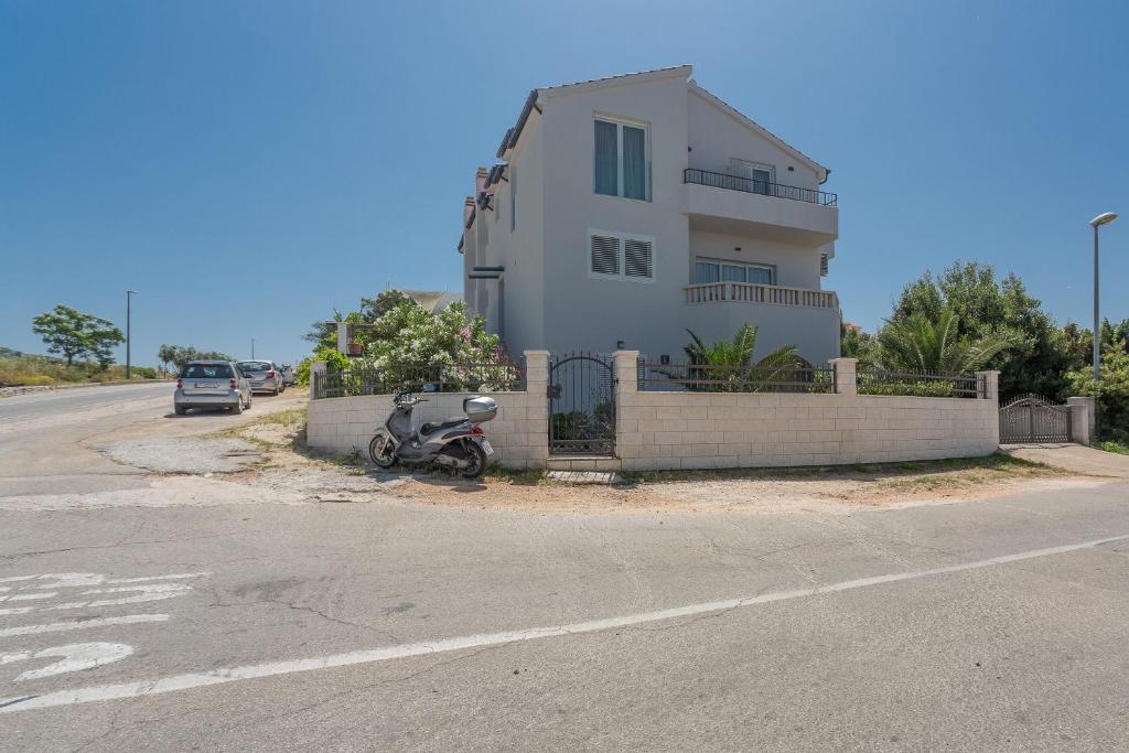 a motorcycle is parked in front of a house at Black and White Spacious Apartment in Hvar
