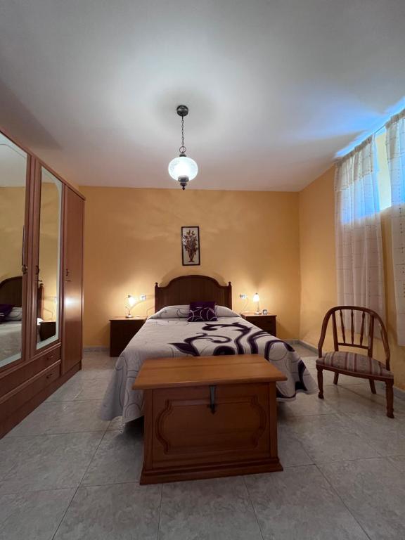 a bedroom with a bed and a table and a chair at A casa do teléfono in Pumares