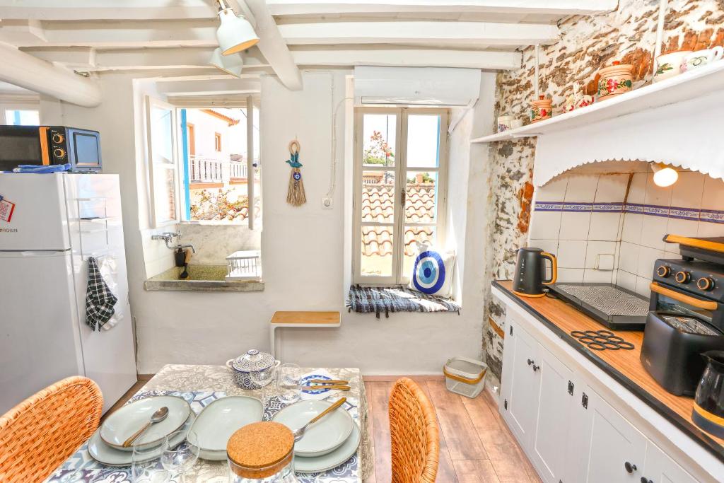 a kitchen with a table and chairs and a refrigerator at Plomari Nest in Plomari