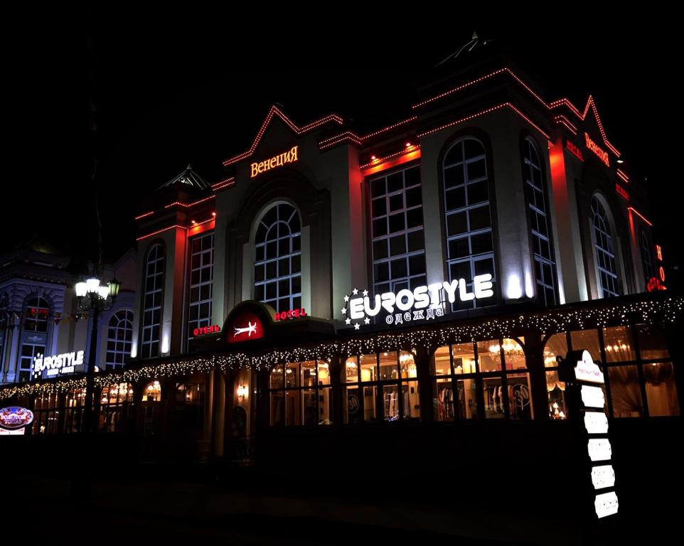een gebouw met 's nachts neonlichten bij Venecia Hotel in Kislovodsk