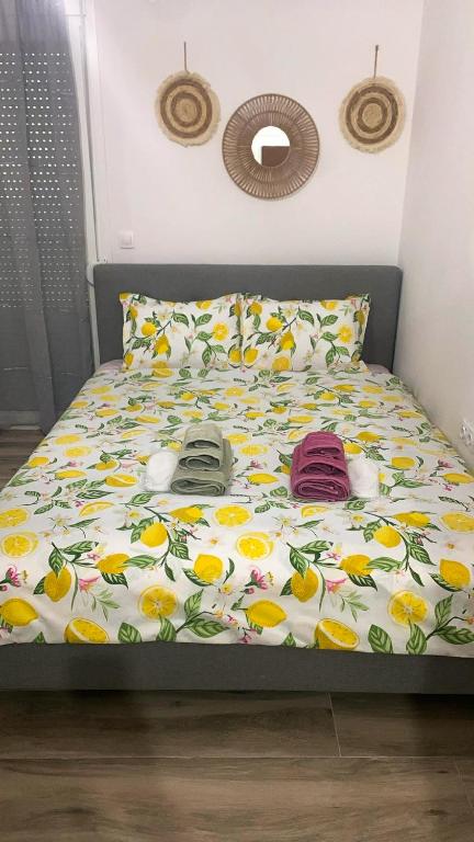 a bed with a comforter with shoes on it at Lemon Luxury Studio in Xanthi