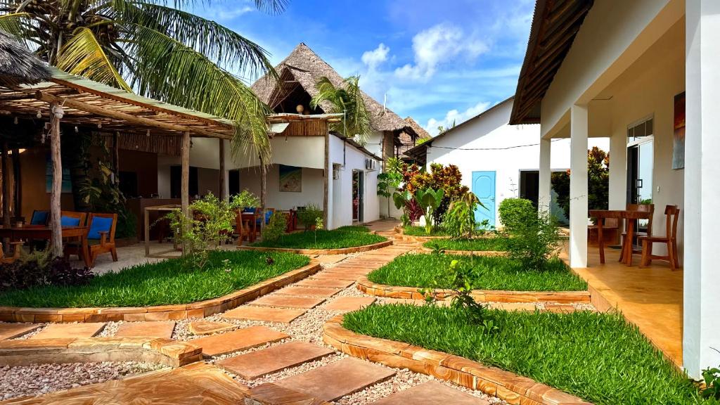a courtyard of a house with a stone walkway at The 5th Element Boutique Hotel in Paje