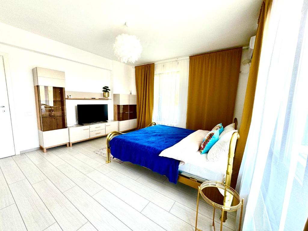 a bedroom with a blue bed and a tv at DAV apart in Otopeni