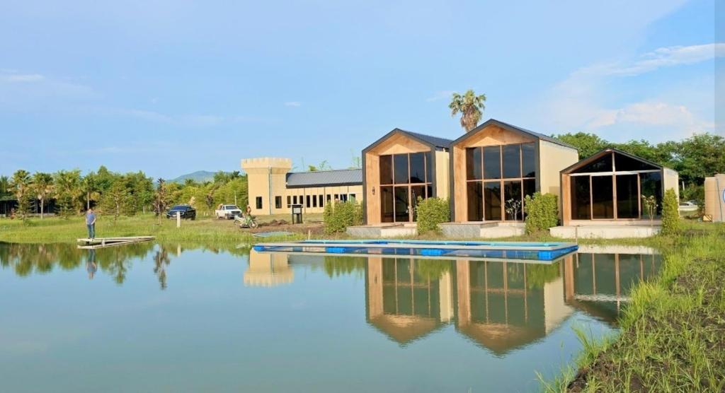 a house with a pond in front of it at Kiangnapa Cottage in Kanchanaburi City