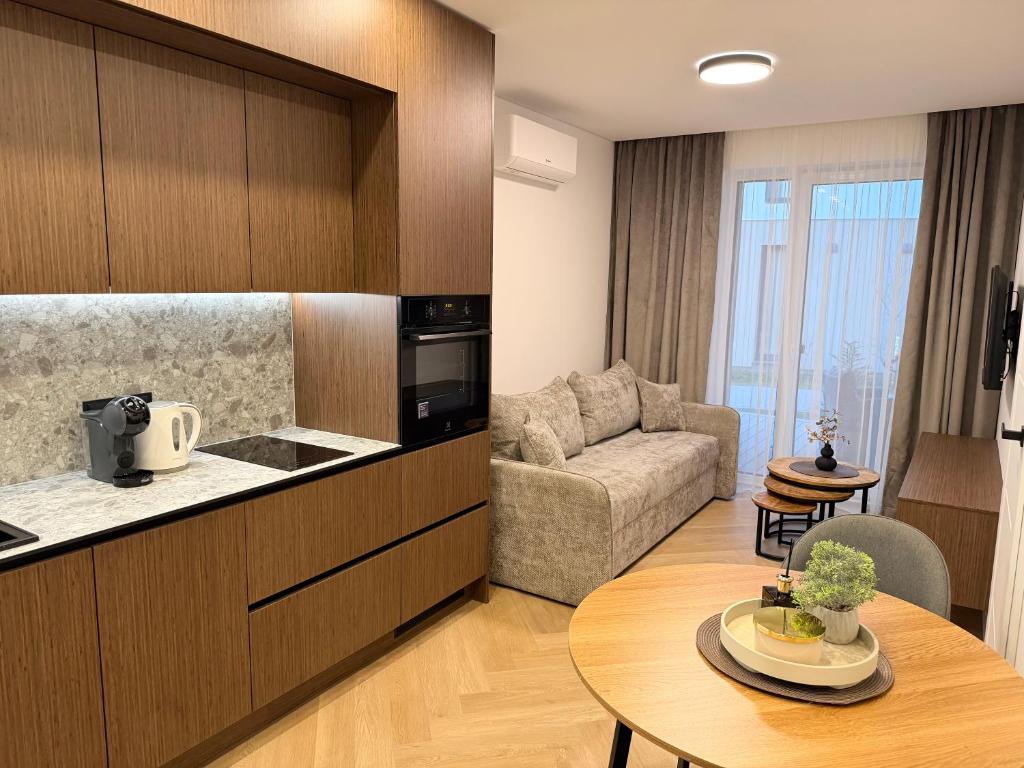 a kitchen and living room with a couch and a table at Pajūrio Namai in Palanga
