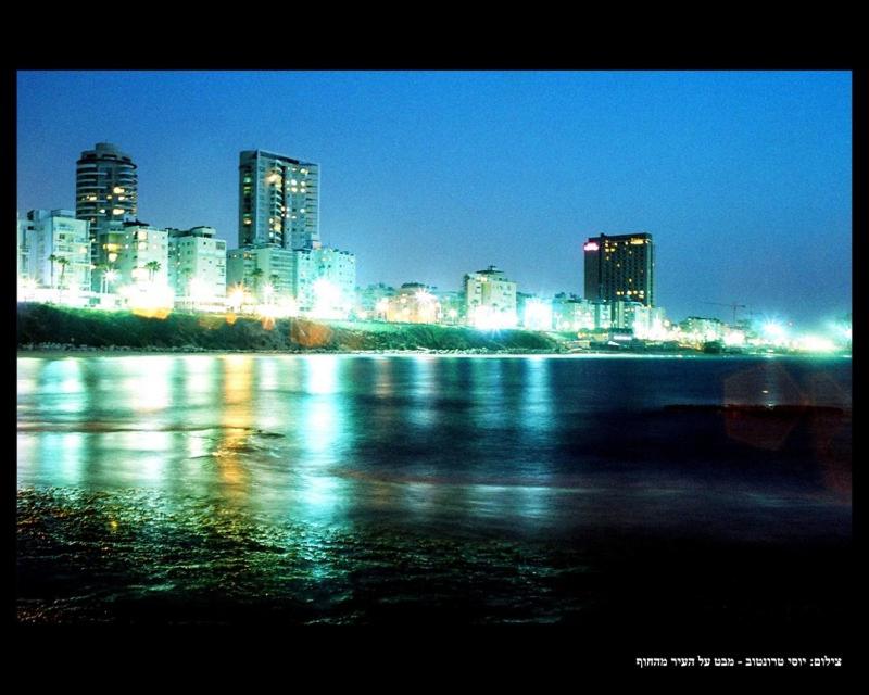 a city skyline at night with a body of water at Isramax Jerusalem Apartment in Bat-Yam in Bat Yam