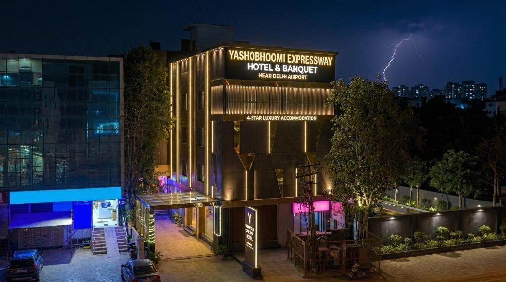 a lightning storm over a building with a sign at Yashobhoomi Hotel Grand Tashree in New Delhi