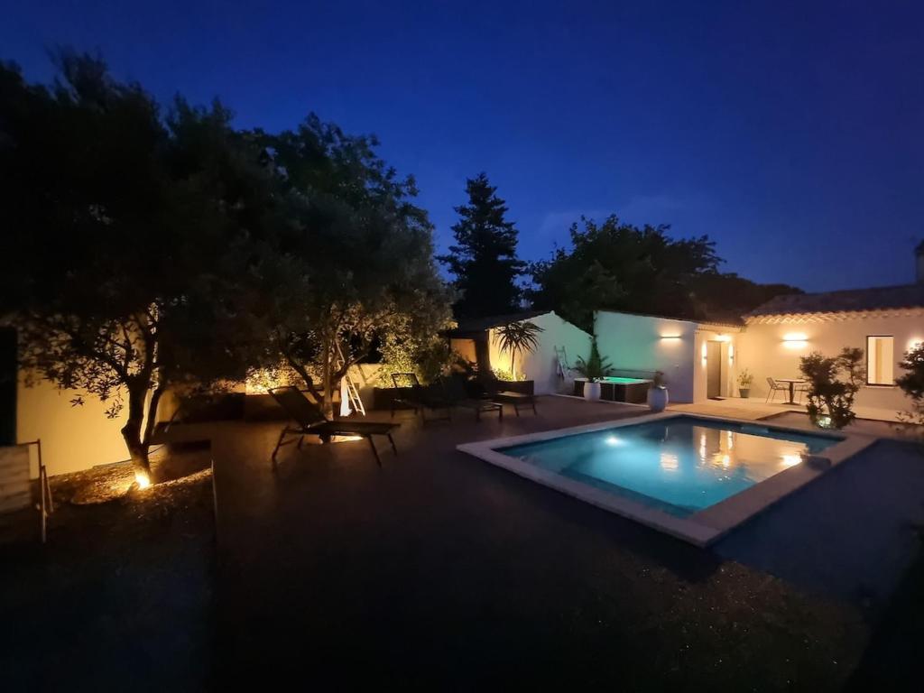 a swimming pool in a yard at night at Escapade à Saint-Saturnin-les-Avignon in Jonquerettes
