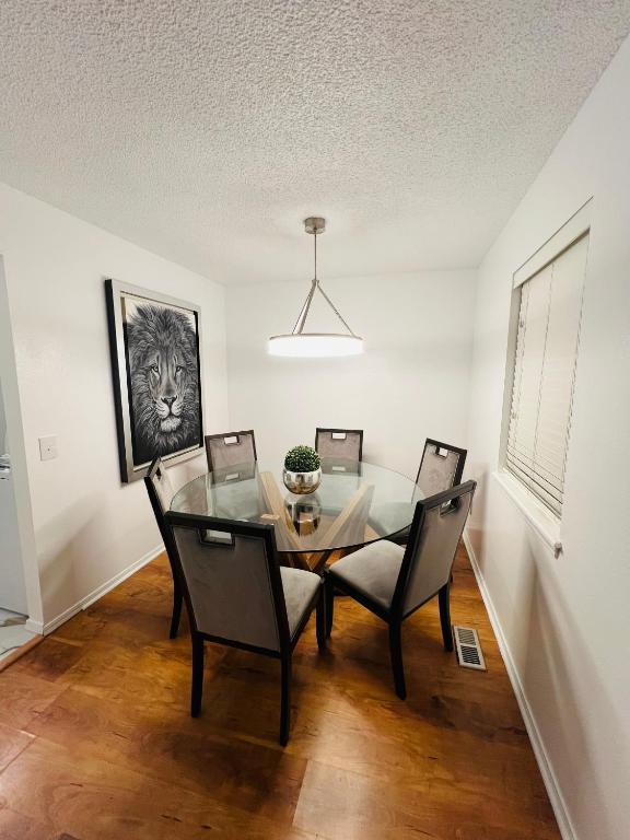 a dining room with a glass table and chairs at Lion House in Bentonville