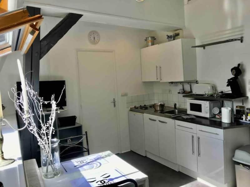 a small kitchen with white cabinets and a microwave at jolie studio 25 in Arras