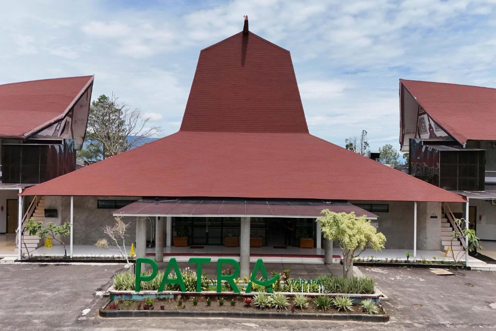 a restaurant with a red roof at Patra Parapat Hotel in Sibagading
