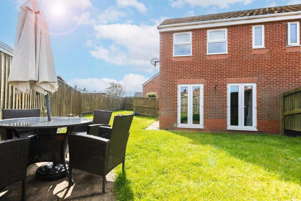 a patio with a table and chairs and a umbrella at Spacious 3BR Durham Home Contractor Friendly in Durham