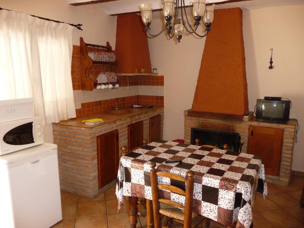 cocina con mesa y fogones horno superior en Casas La Piedra De Tíscar, en Tíscar