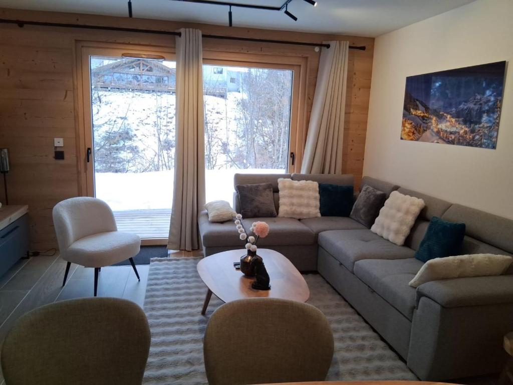 a living room with a couch and a table at L Ecrin des Cimes 6 voyageurs in Arâches-la-Frasse