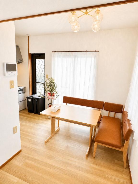 a living room with a wooden table and a couch at Glad Kasuga in Kasugabaru