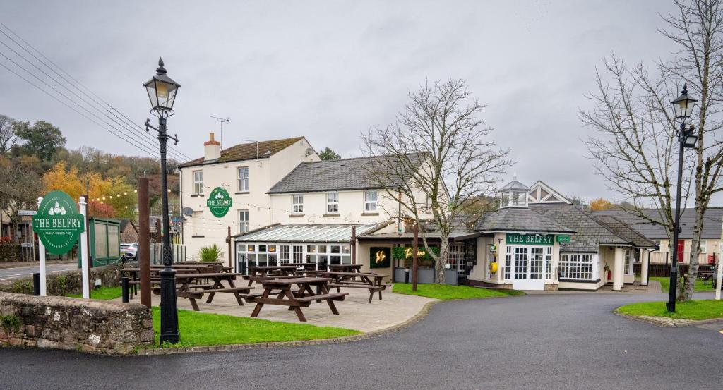 a group of picnic tables in front of a building at The Belfry, Littldean in Little Dean