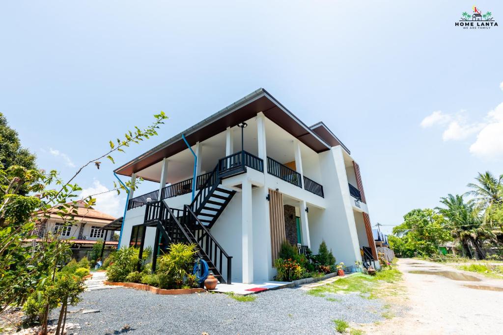 a house with a staircase in front of it at Ck Home Lanta in Phra Ae beach