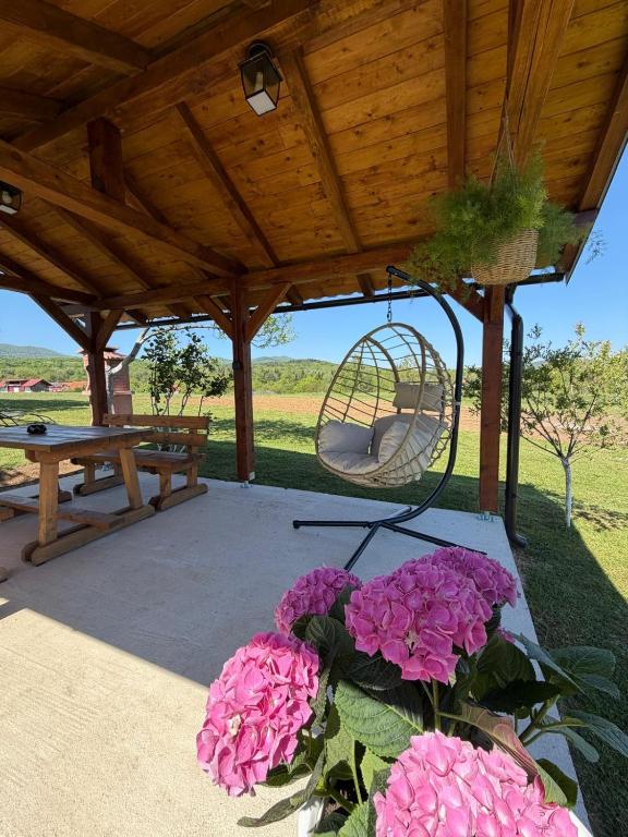 a picnic shelter with pink flowers and a swing at House Turkalj in Grabovac