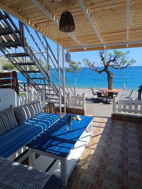 a patio with blue and white chairs and the ocean at Sea Sound Haraki apartment in Haraki