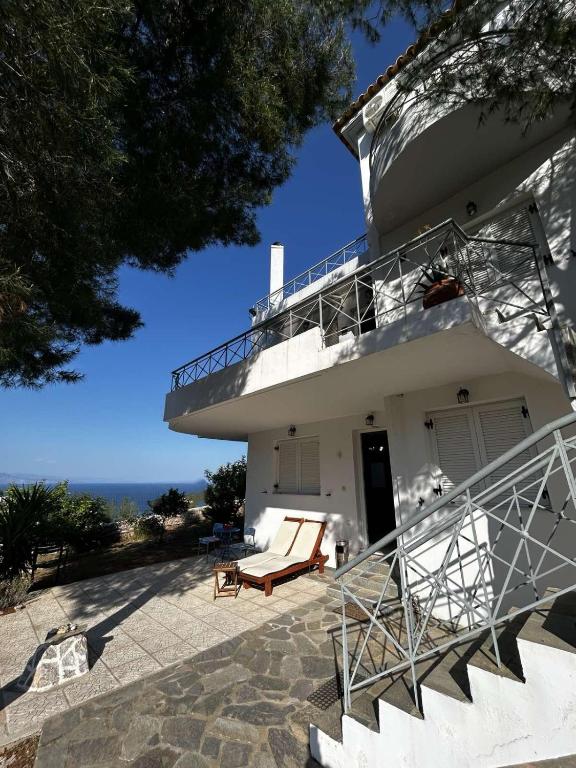 a white house with stairs and a balcony at Mikro Amoni Beach Villa in Pefkali